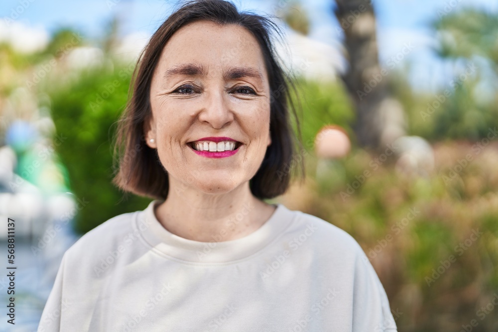 Middle age woman smiling confident standing at park Middle age woman smiling confident standing at park