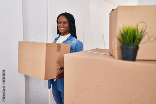 African american woman smiling confident holding package at new home © Krakenimages.com