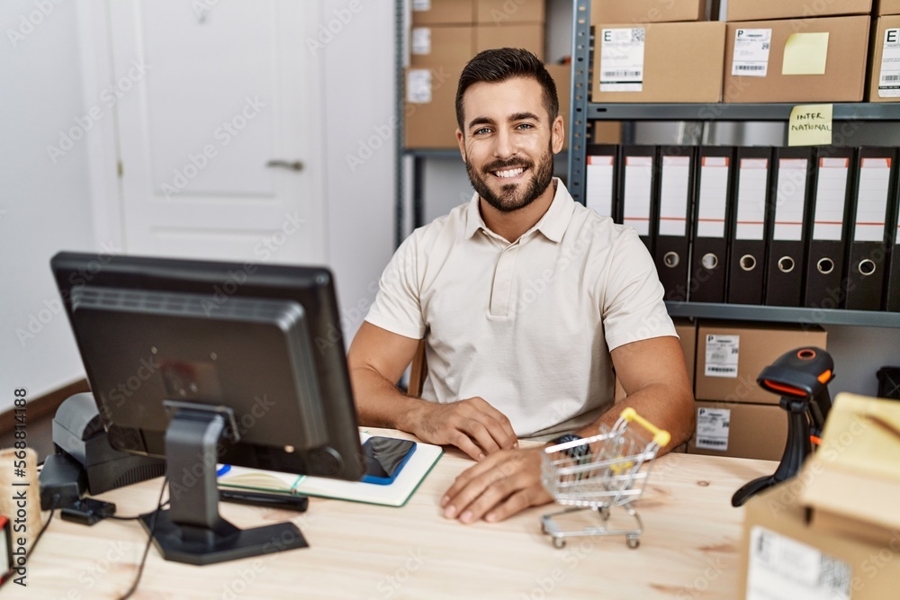 Handsome hispanic man working at small business commerce with a happy and cool smile on face. lucky person.