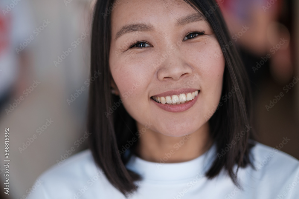 Enthusiastic asian woman rejoicing, looking happy, standing on blurred background Enthusiastic asian woman rejoicing, looking happy, standing on blurred background