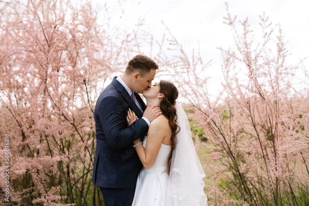 the groom and the bride are walking in the forest