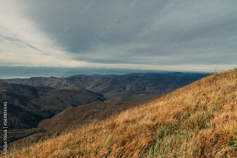 View from a great height in a picturesque place of the Caucasus. The mountain range of the Caucasus against the background of clouds.Mountain pass, mountain range. Beautiful mountain landscape. View from a great height in a picturesque place of the Caucasus. The mountain range of the Caucasus against the background of clouds.Mountain pass, mountain range. Beautiful mountain landscape.