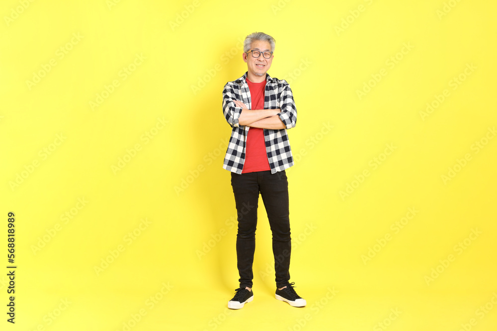 Fototapeta premium The 40s adult Asian man with casual dressed standing on the yellow background.