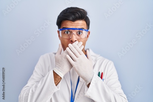 Hispanic man working as scientist shocked covering mouth with hands for mistake. secret concept.
