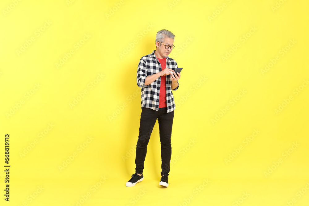 Fototapeta premium The 40s adult Asian man with casual dressed standing on the yellow background.
