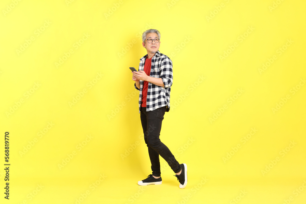 The 40s adult Asian man with casual dressed standing on the yellow background.