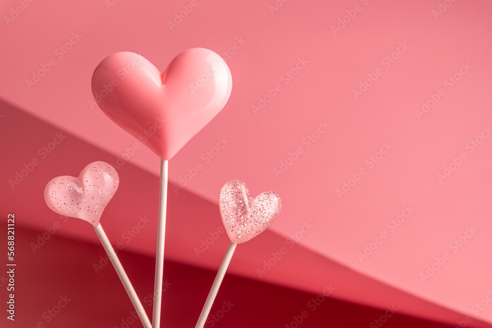 three Pink Valentine's day heart shape lollipop candy on empty pastel paper background. Love Concept