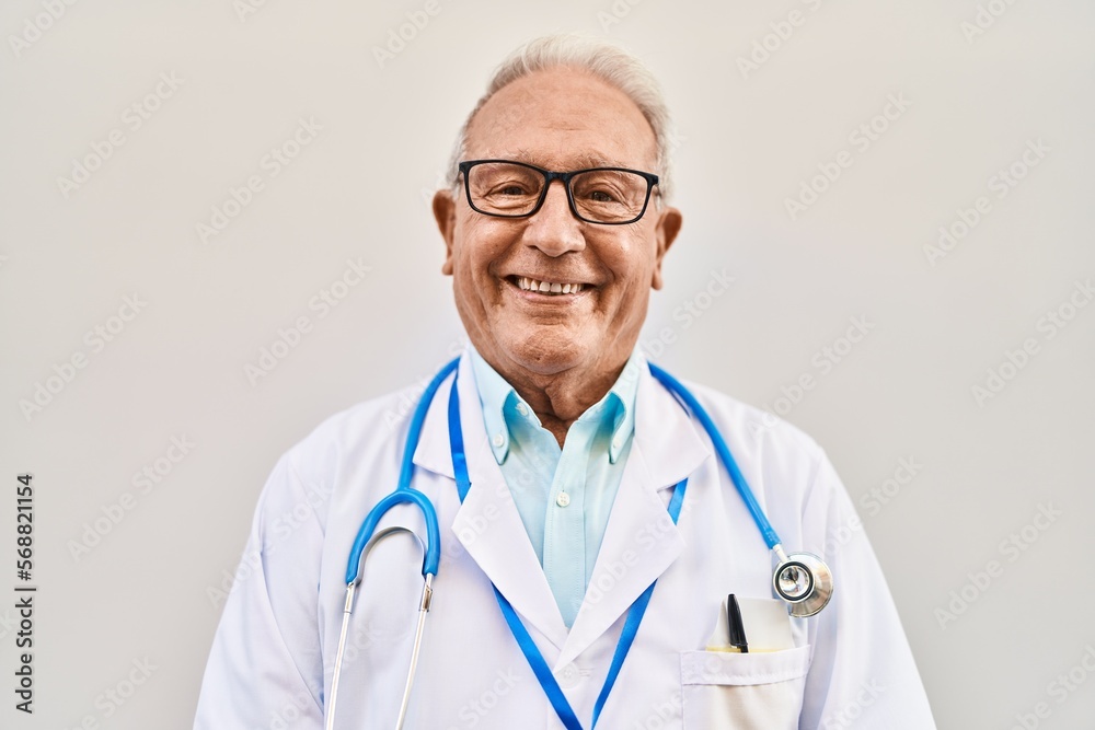 Senior man wearing doctor uniform standing over white isolated background Senior man wearing doctor uniform standing over white isolated background