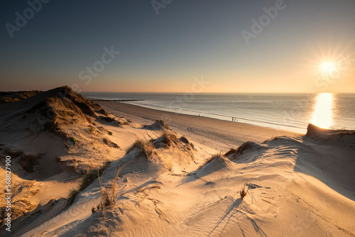 golden sunshine over sand dunes and sea beach