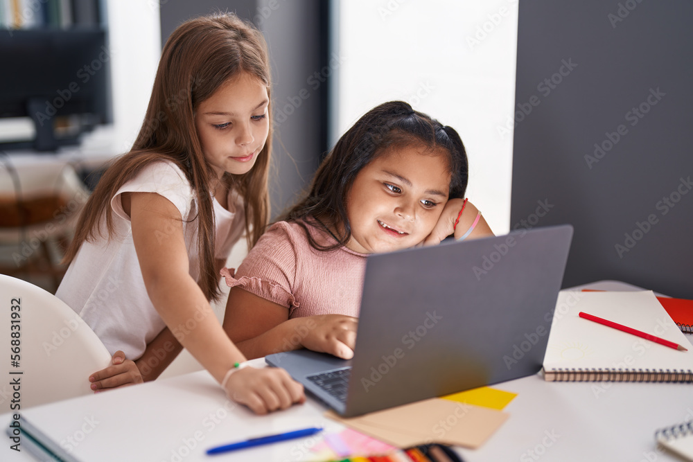 Two kids students using laptop studying at classroom Two kids students using laptop studying at classroom