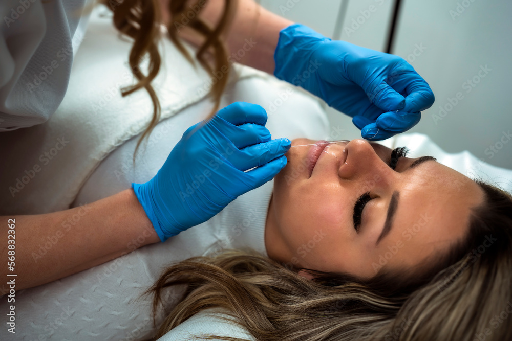 Makeup artist applay permanent makeup procedure. Lips makeup in the cosmetologist's salon. Makeup artist applay permanent makeup procedure. Lips makeup in the cosmetologist's salon.
