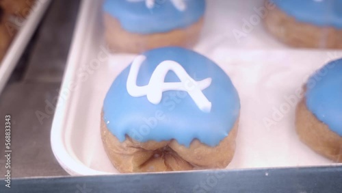 Blue icing sugar donuts with white LA letters on top. Close up.