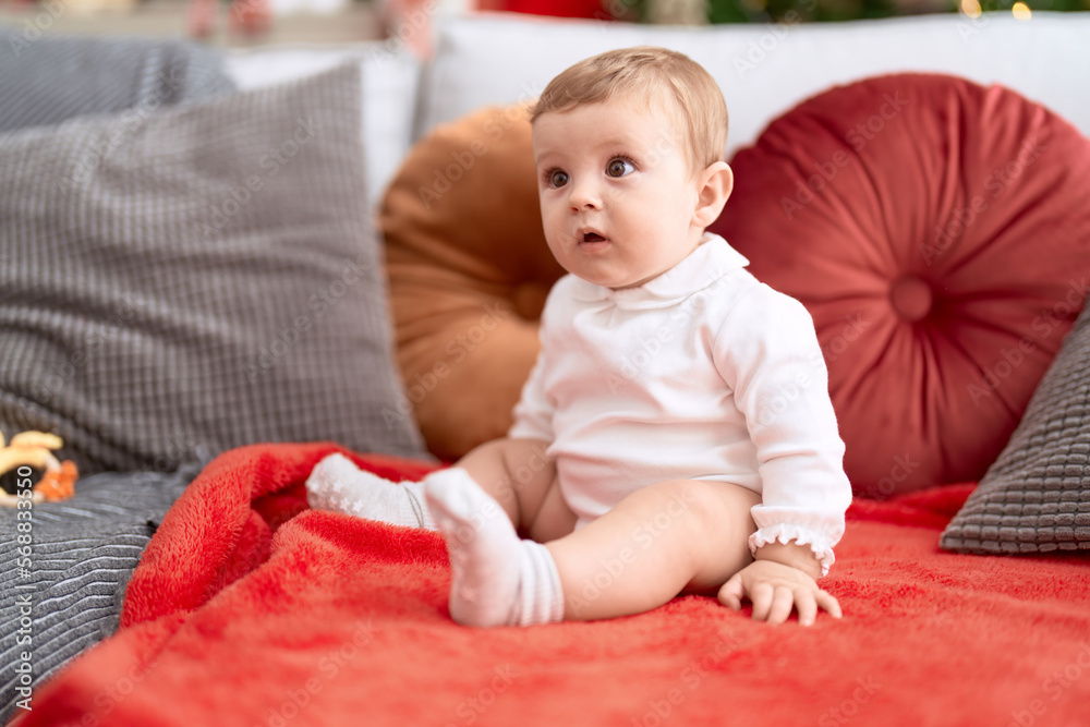 Adorable toddler sitting on sofa with relaxed expression at home Adorable toddler sitting on sofa with relaxed expression at home