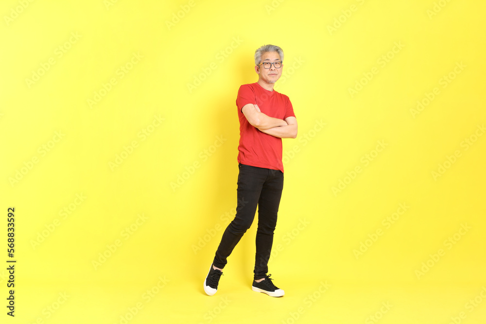 The 40s adult Asian man with casual dressed standing on the yellow background.