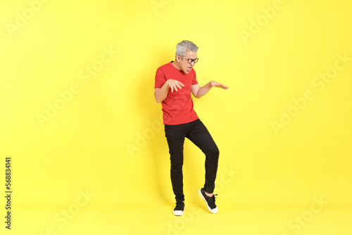 Fototapeta Naklejka Na Ścianę i Meble -  The 40s adult Asian man with casual dressed standing on the yellow background.