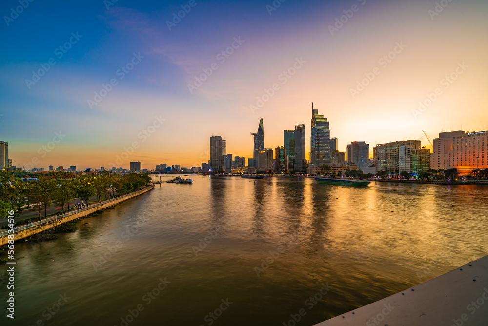 Naklejka premium Ho Chi Minh City, Viet Nam 02 Jan 2023: Beautiful Sunset at district 1, view to Bitexco tower with Vietnam flag on the top building. One of the famous buildings in ho chi minh city