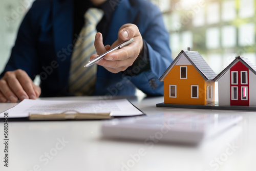 Real estate agents explaining the terms of signing contracts, legal agreements, land purchases, mortgages and home rentals.