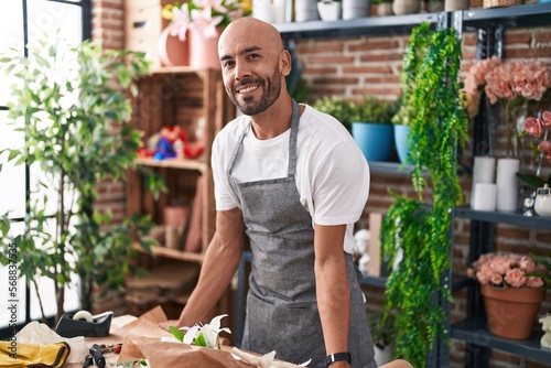 Young bald man florist smiling confident standing at florist