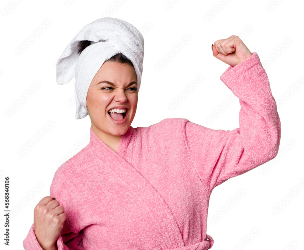 Young caucasian woman in bathrobe isolated raising fist after a victory, winner concept. Young caucasian woman in bathrobe isolated raising fist after a victory, winner concept.