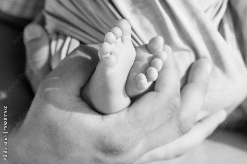 Baby feet in father hands. Tiny newborn baby's feet on male hands closeup. Dad and his child. Happy Family concept. Beautiful conceptual image of parenthood Baby feet in father hands. Tiny newborn baby's feet on male hands closeup. Dad and his child. Happy Family concept. Beautiful conceptual image of parenthood