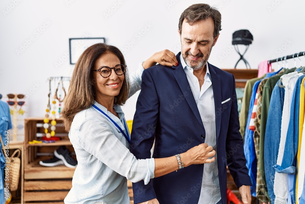 Middle age man and woman smiling confident choosing clothes at clothing store Middle age man and woman smiling confident choosing clothes at clothing store