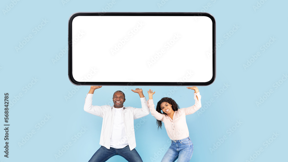 African american couple holding huge heavy smartphone with mockup on blank screen above their heads African american couple holding huge heavy smartphone with mockup on blank screen above their heads