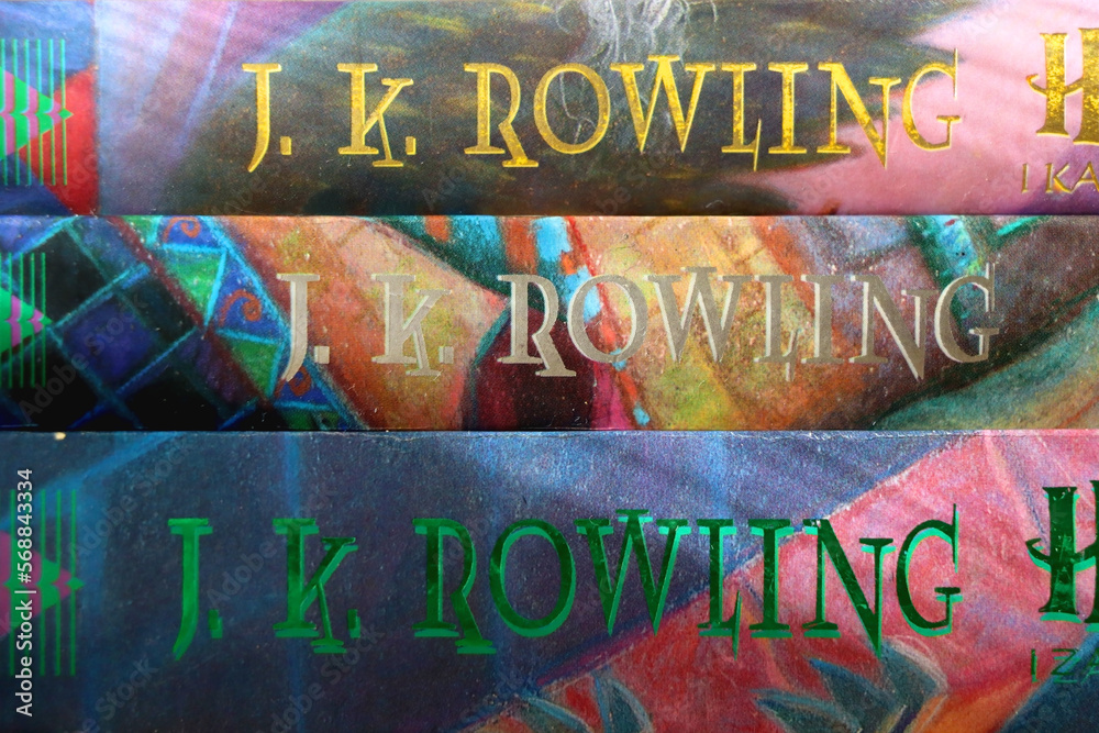 Fototapeta premium Split, Croatia - January 15, 2023: Stack of fantasy books by famous author J. K. Rowling. Bookshelf in the background. Selective focus.
