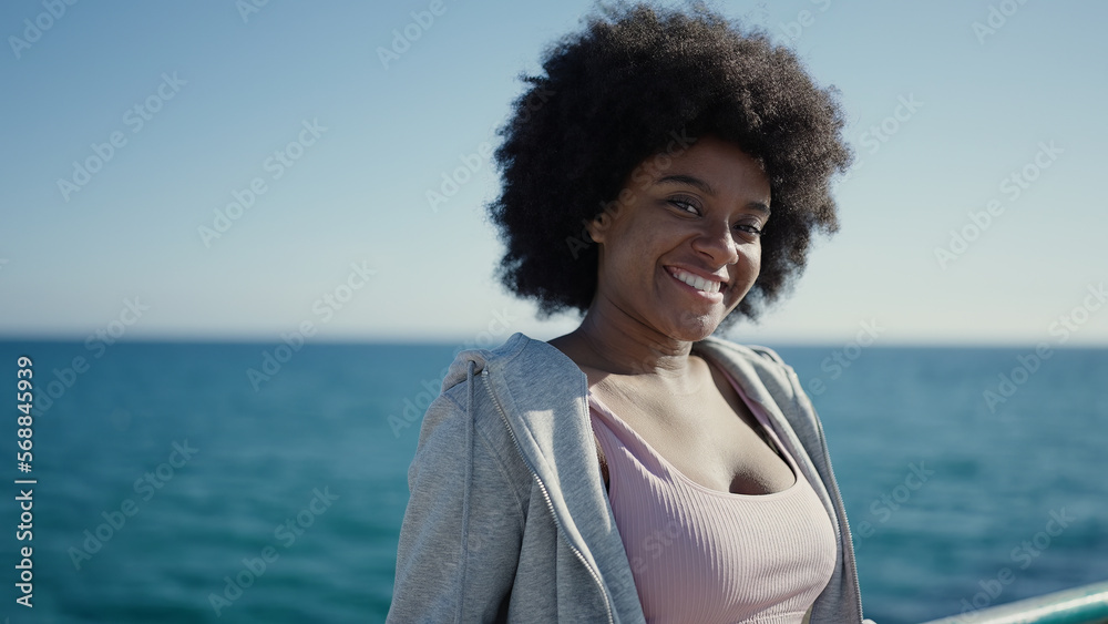 African american woman smiling confident leaning on balustrade at seaside