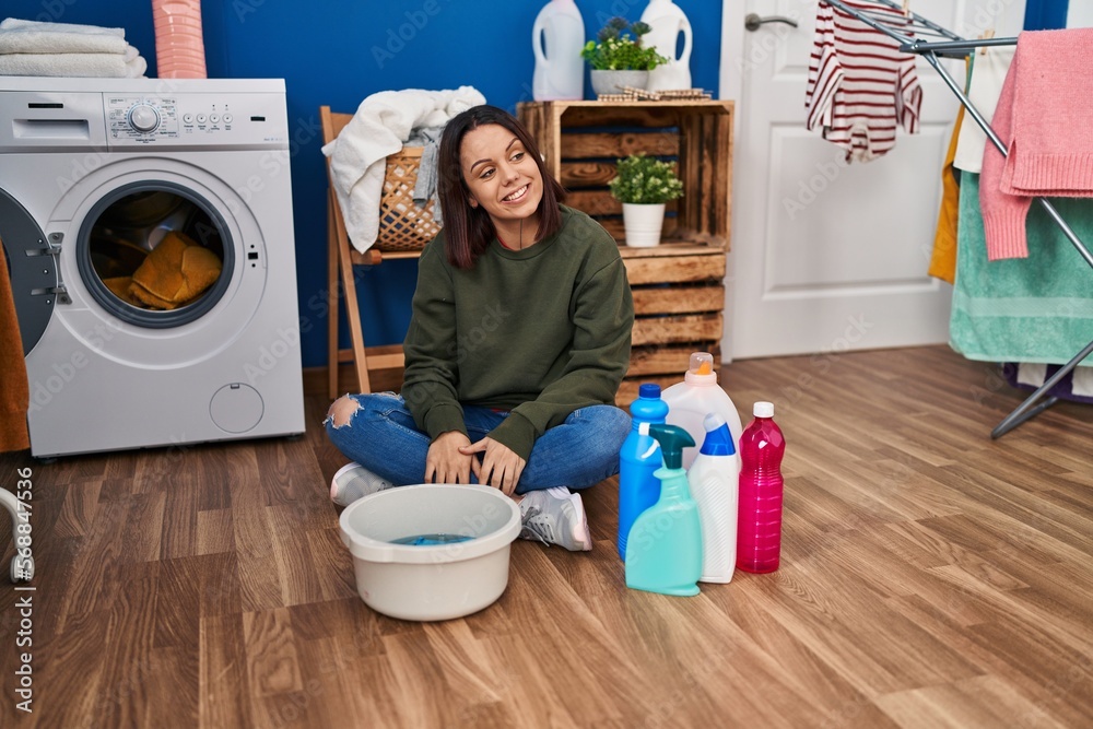 Young hispanic woman doing laundry washing by hand looking away to side with smile on face, natural expression. laughing confident. Young hispanic woman doing laundry washing by hand looking away to side with smile on face, natural expression. laughing confident.
