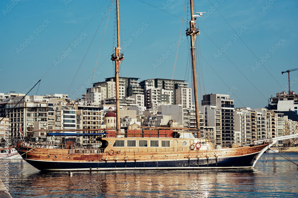 wooden sailing ship in the port of the capital of Malta buildings in the area of Sliema