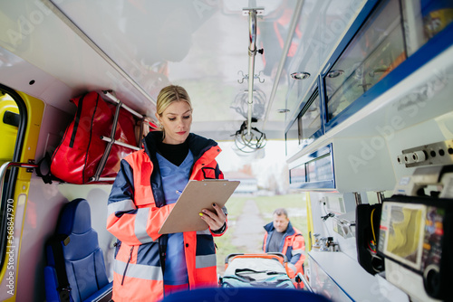 Young rescuer doctor checking equipment in ambulance car.