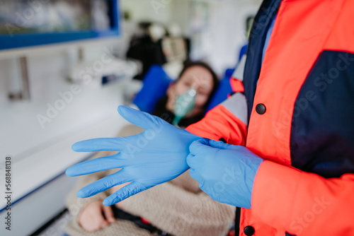 Close-up of rescuer putting on surgical gloves before examination of patient.