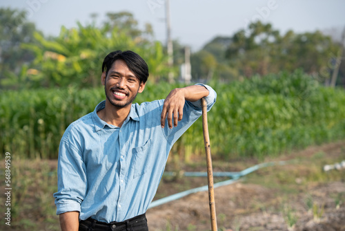 Portrait of happy young gardener with a spade ready for his work during the day.