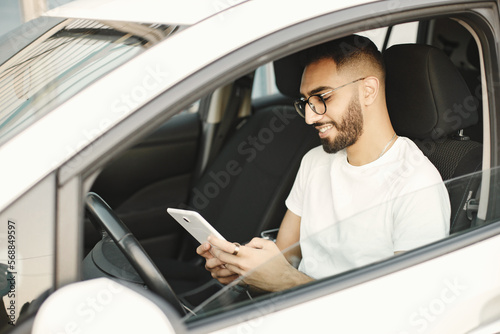 Male driver using a phone while sitting in a car