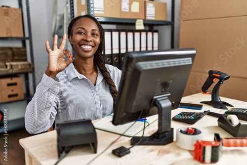 Wallpaper Mural African woman working at small business ecommerce smiling positive doing ok sign with hand and fingers. successful expression. Torontodigital.ca