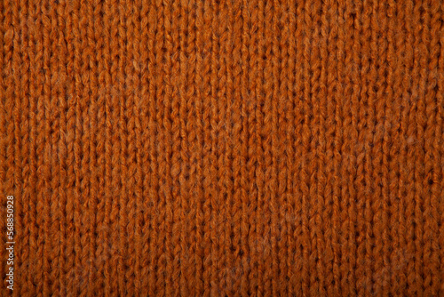 Autumn concept - background of knitted woolen brown sweater. Knit fabric texture. Close up view. Knitted background