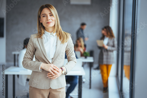 Shot of a confident young businesswoman standing in a modern office. Portrait of a businesswoman standing in the office. One Happy Pretty Business Woman Standing in office photo