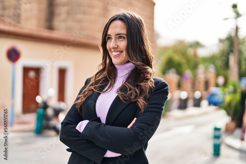 Young hispanic woman smiling confident standing with arms crossed gesture at street