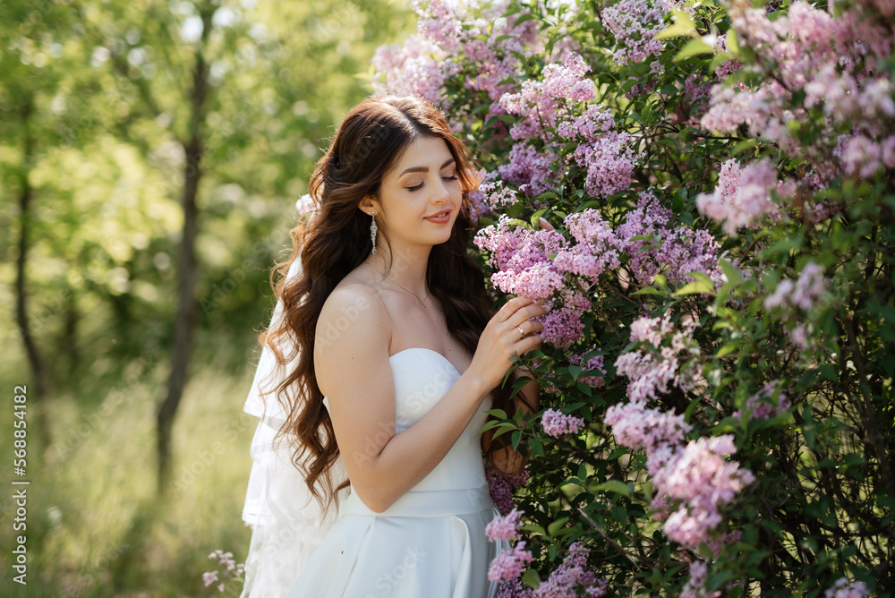 young girl bride in a white dress in a spring forest in lilac bushes young girl bride in a white dress in a spring forest in lilac bushes