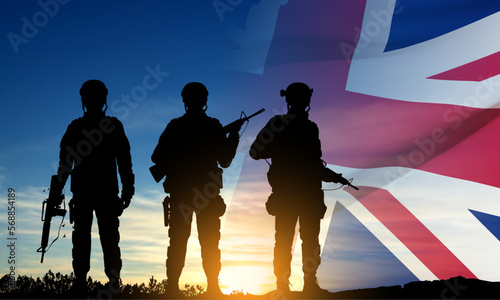 Silhouettes of a soldiers with United Kingdom flag on background of sunset. Background for Remembrance Day. United Kingdom Armed Forces concept. EPS10 vector