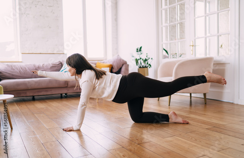 Young woman practicing prenatal yoga while doing Balancing Table pose