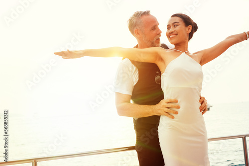 Senior business man hugging his wife and doing freedom dancing celebration event on the yacht deck,Silhouette romance scene marriage anniversary over sunset, luxury and happiness moment
