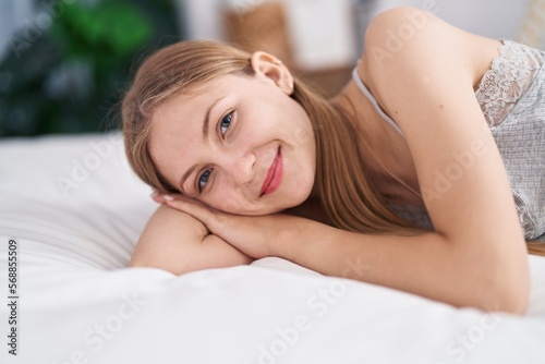 Young caucasian woman smiling confident lying on bed at bedroom