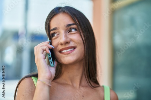 Young beautiful hispanic woman smiling confident talking on the smartphone at street