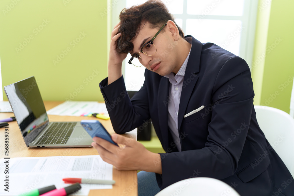 Non binary man business worker using smartphone with relaxed expression at office Non binary man business worker using smartphone with relaxed expression at office