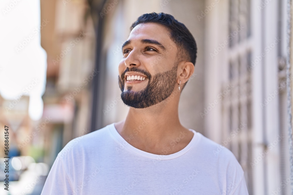 Obraz premium Young arab man smiling confident looking to the side at street