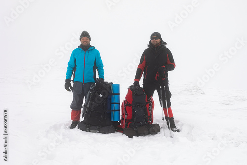 Men with backpacks and snowshoes on a winter hike.