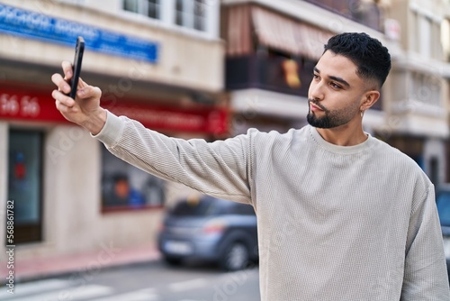 Young arab man making selfie by the smartphone at street