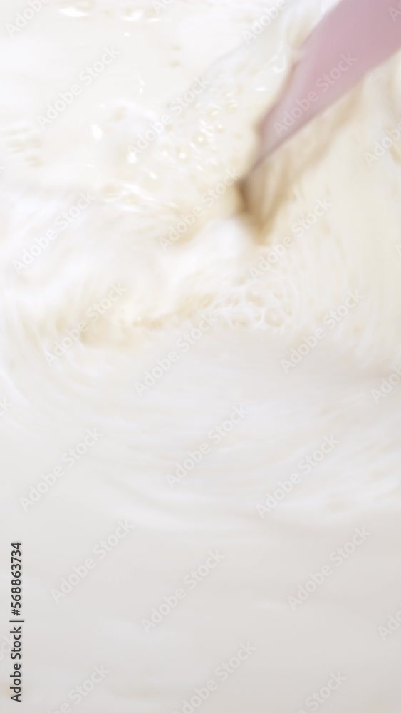 Vertical slow motion video, using a spatula to mix farm fresh milk, healthy milk drink concept. Vertical slow motion video, using a spatula to mix farm fresh milk, healthy milk drink concept.