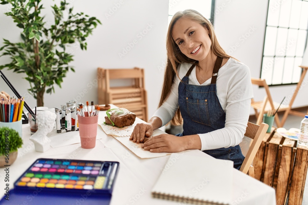 Young caucasian woman smiling confident make handmade clay pot at art studio